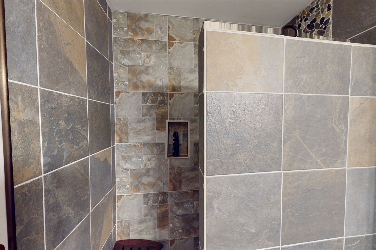 Elegant ski lodge–style bath with walk-in shower and natural stone detailing.