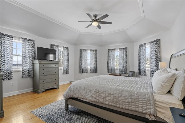 This serene primary bedroom offers panoramic lake views, along with a king bed, TV, desk+chair,  and generous closet space for a comfortable extended stay.