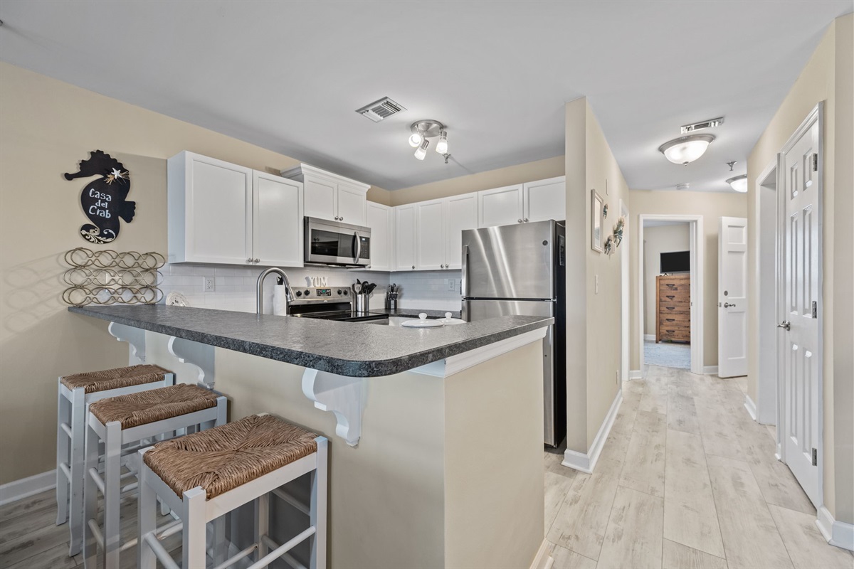 Fully equipped kitchen with stainless steel appliances and a convenient breakfast bar for casual dining