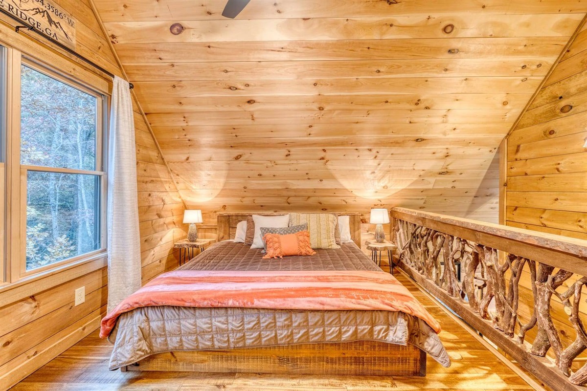 Our cozy bed upstairs beckons, offering a retreat from the world below. Wrapped in soft blankets and plush pillows, it's the perfect sanctuary for peaceful nights and dream-filled slumbers in our charming cabin
