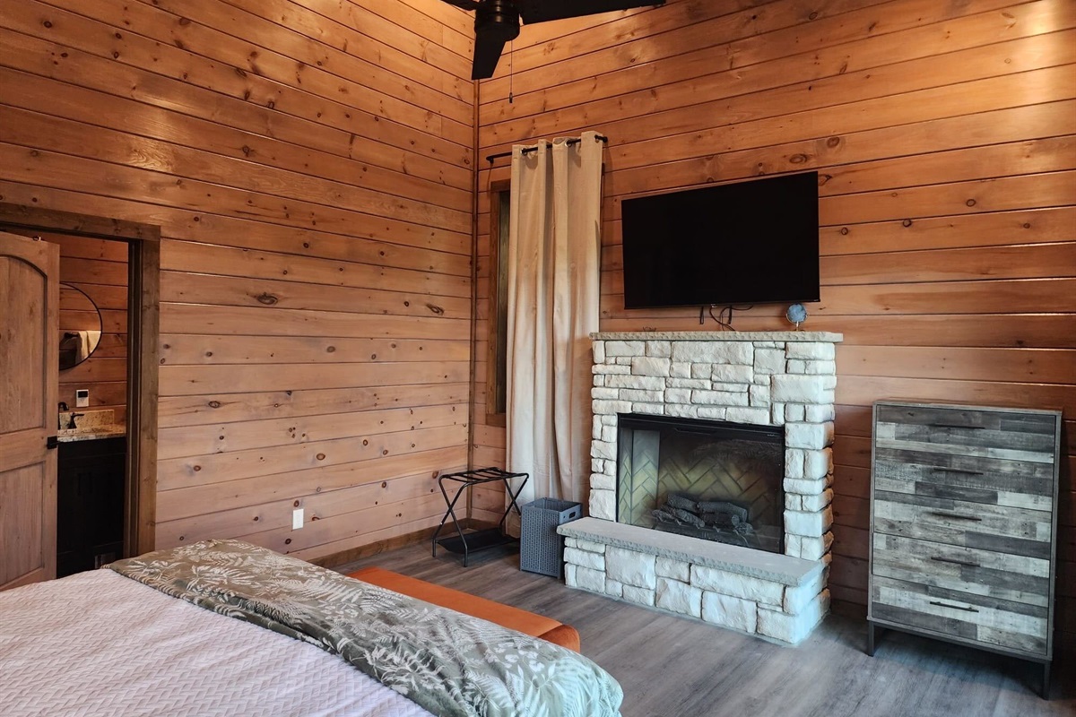 Bedroom with fireplace and wall-mounted TV