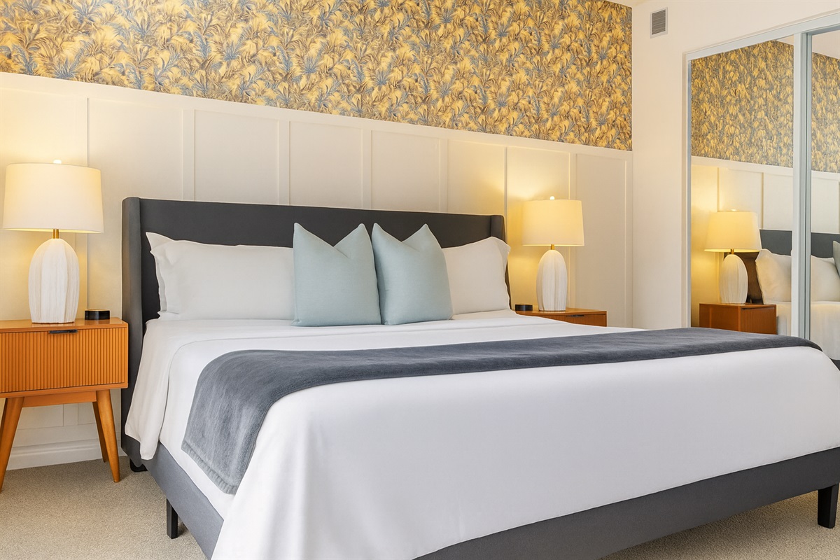 Primary bedroom with king bed, nightstands, lamps, and vibrant wall art for a welcoming retreat.