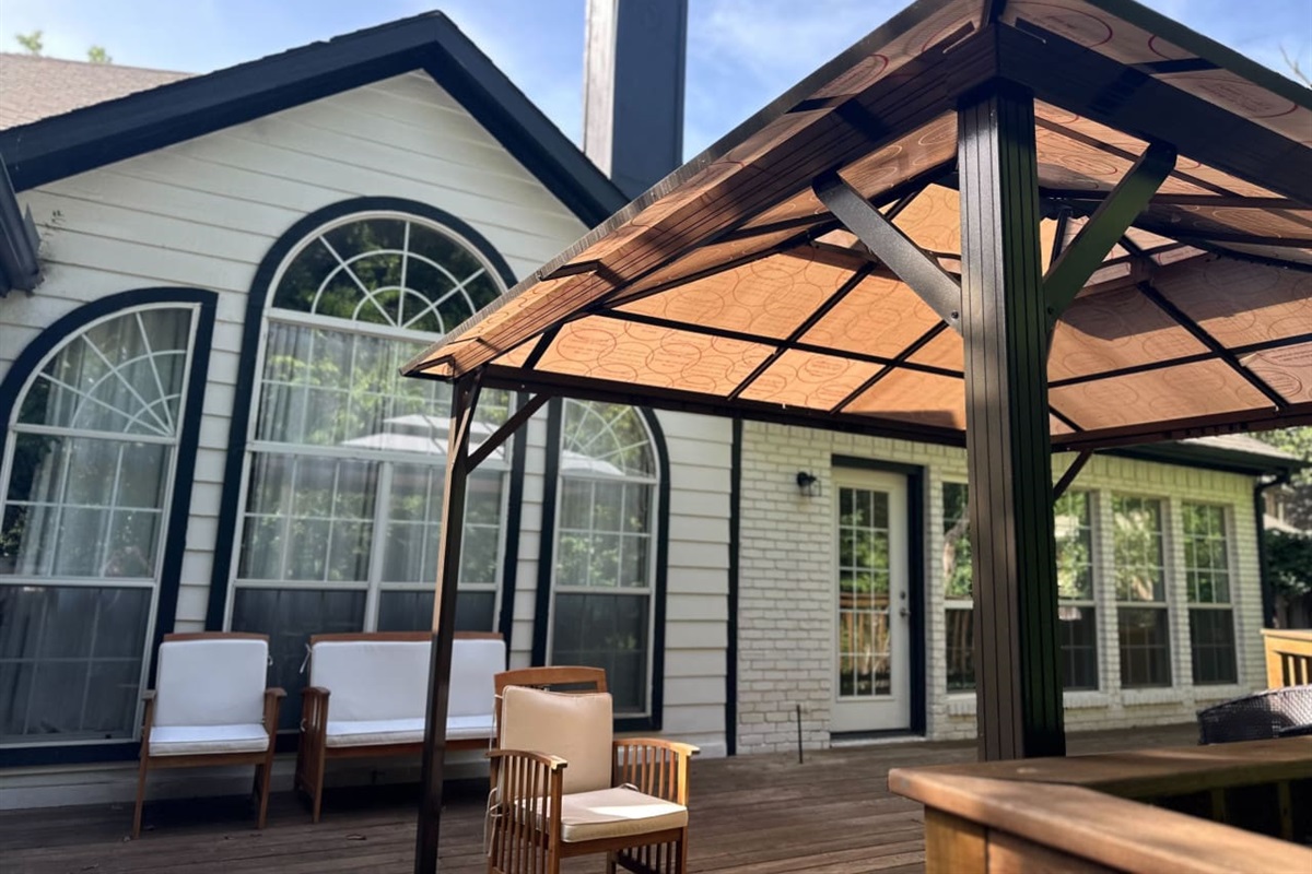 Spacious backyard with privacy fence, large deck, and BBQ grill.