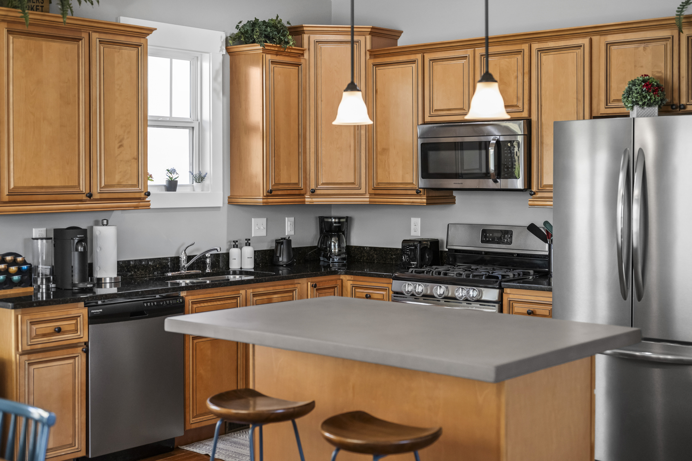 Gather around a large kitchen island.  Well stocked kitchen with expanded concrete kitchen island.  This home provides dish soap, hand soap, dishwasher soap, paper towels, garbage bags, & more for guest use during your stay.