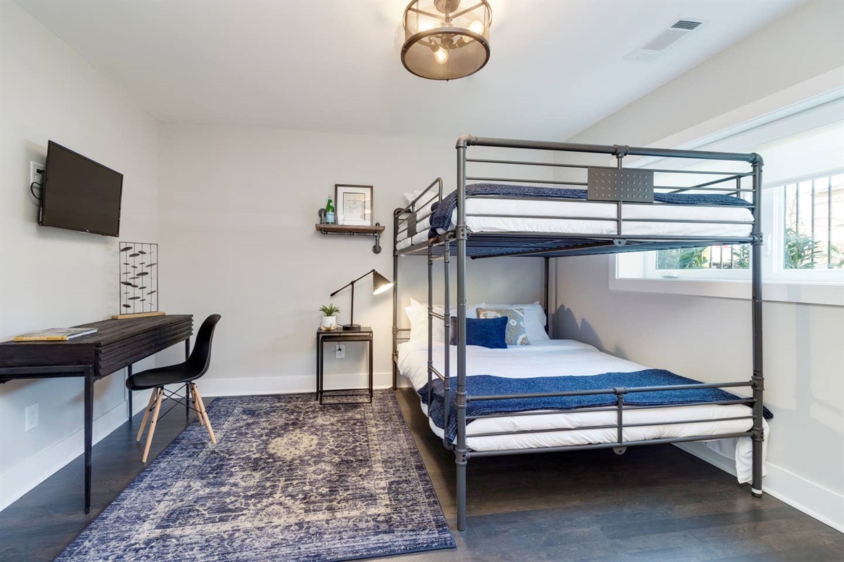 - Metal bunk bed with full bottom & twin top, dressed in crisp white & navy linens - Dedicated desk & reading lamp offer the perfect nook for remote work or journaling - Cozy navy rug, sleek décor, & wall mounted TV bring comfort & function together