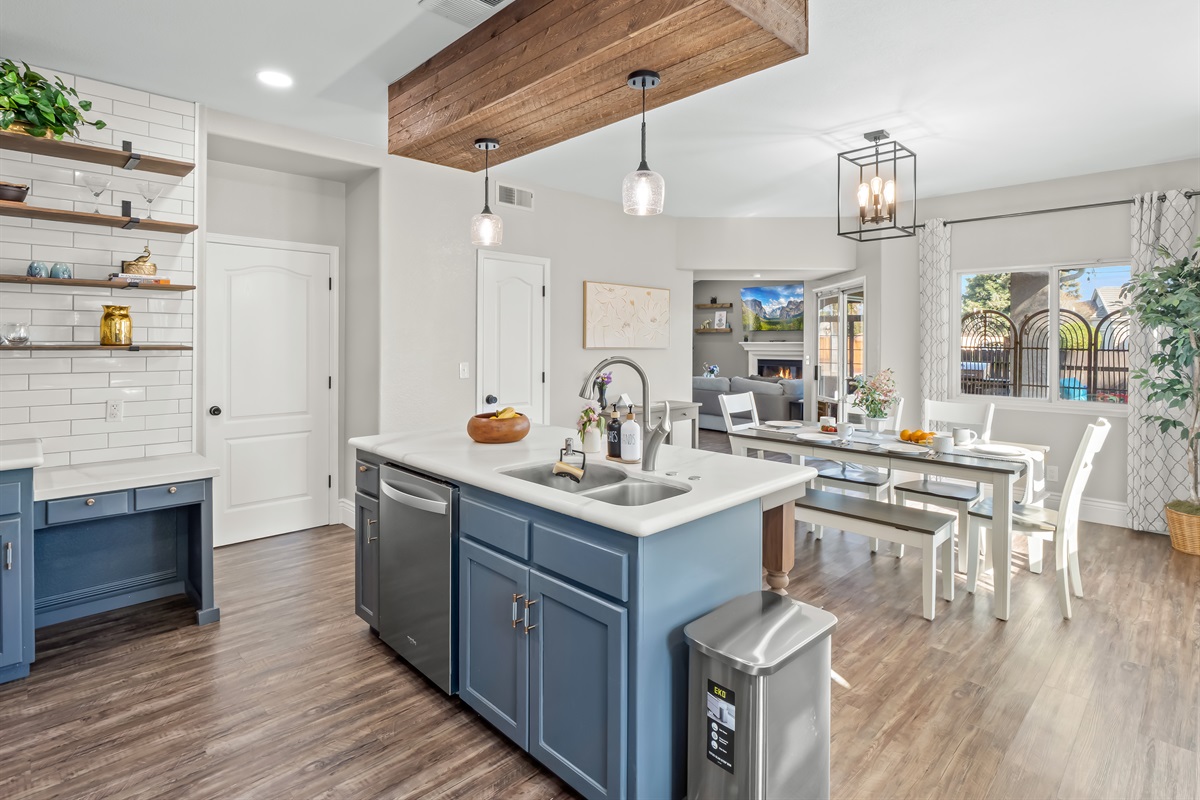 Open-concept kitchen and dining area with a large island, double sink, dishwasher, stainless steel appliances, and plenty of seating—perfect for family meals and easy cleanup.