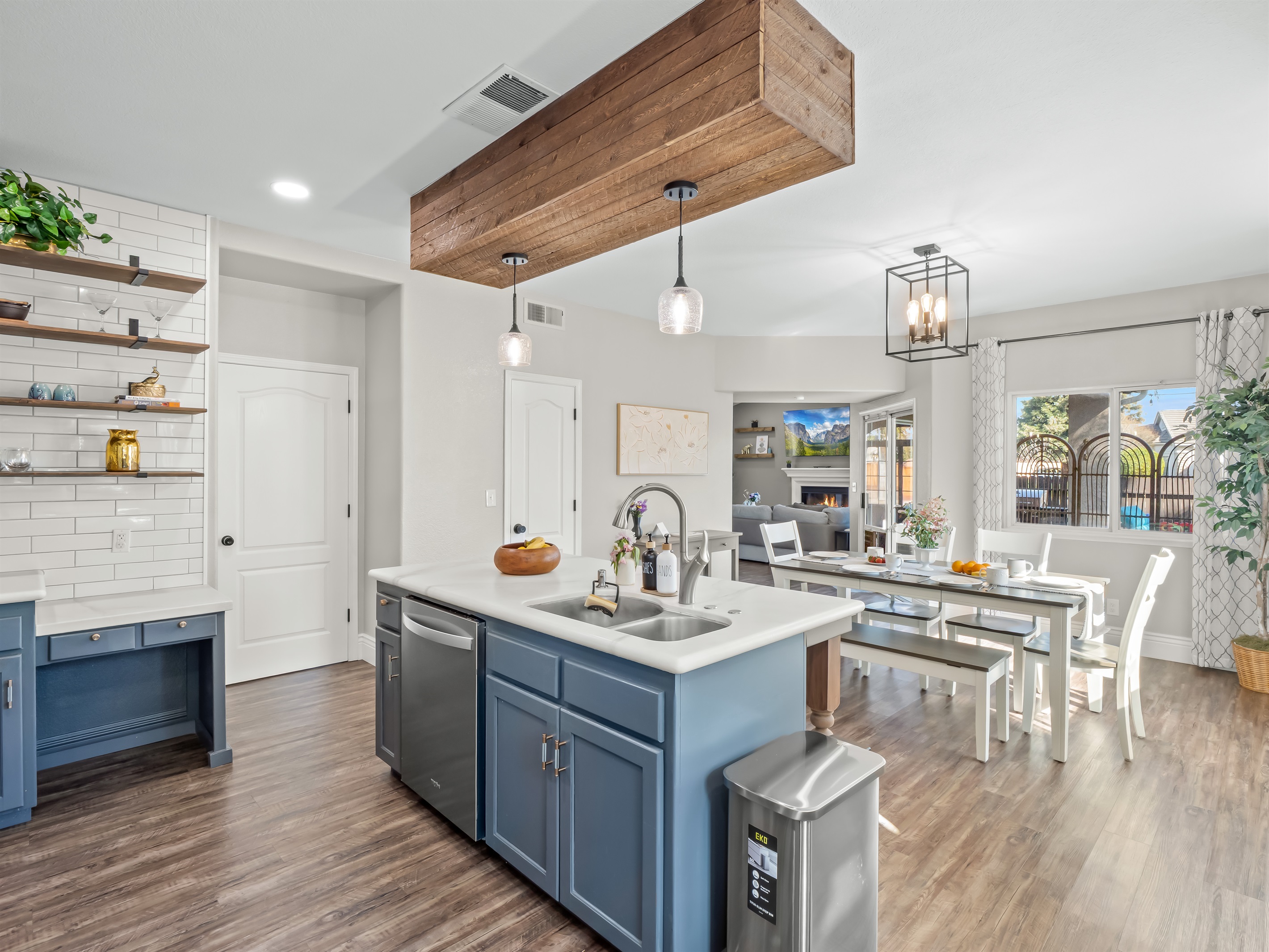 Open-concept kitchen and dining area with a large island, double sink, dishwasher, stainless steel appliances, and plenty of seating—perfect for family meals and easy cleanup.
