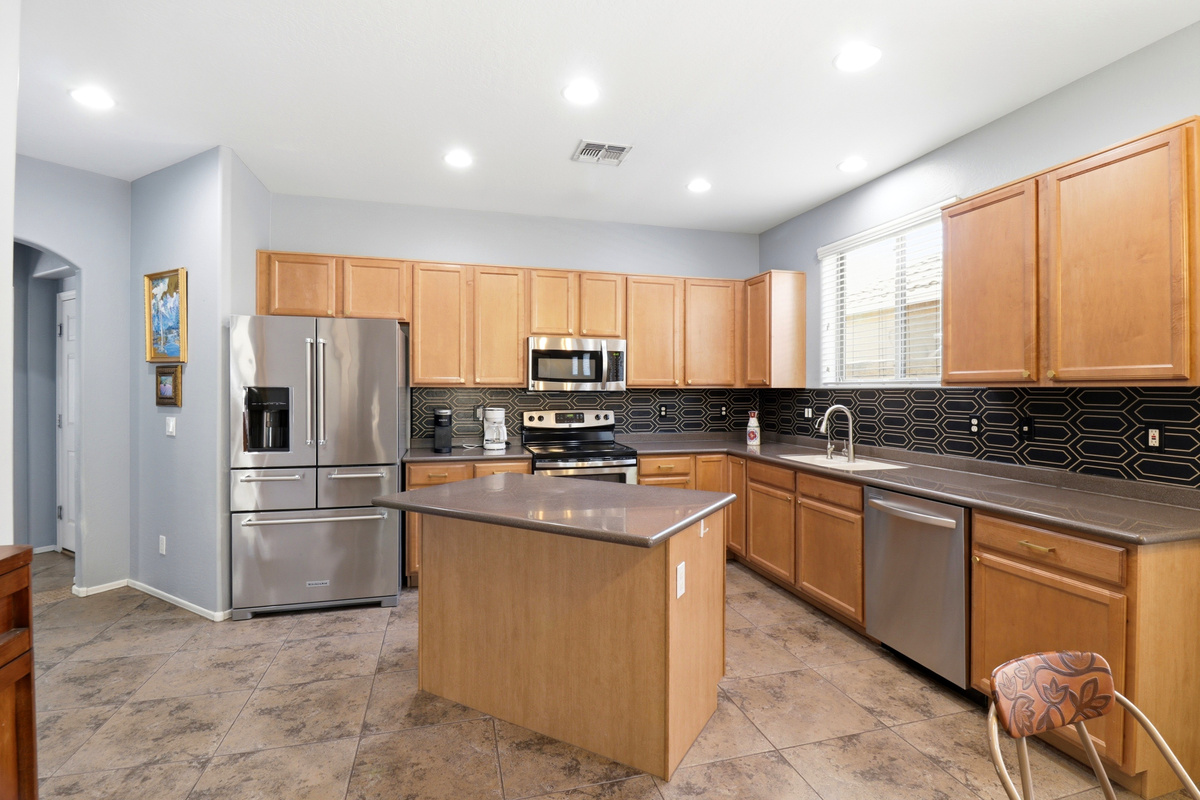 Kitchen with a center island, full appliances, and plenty of space for cooking or serving meals.
