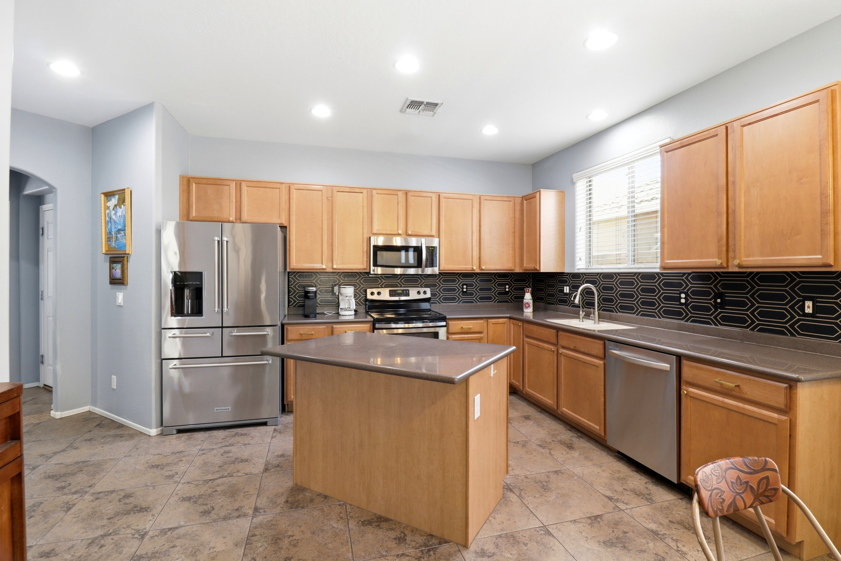 Kitchen with a center island, full appliances, and plenty of space for cooking or serving meals.
