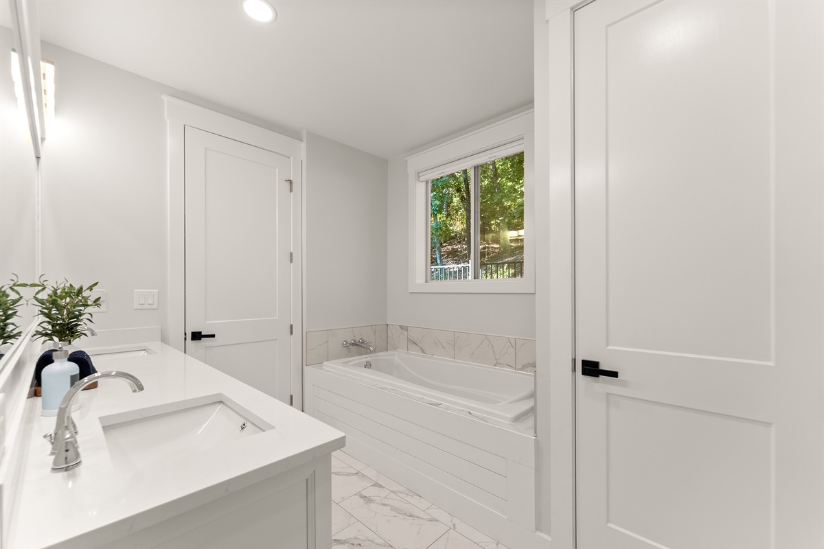 Bright, spa-like ensuite with soaking tub and walk-in shower — your private sanctuary.