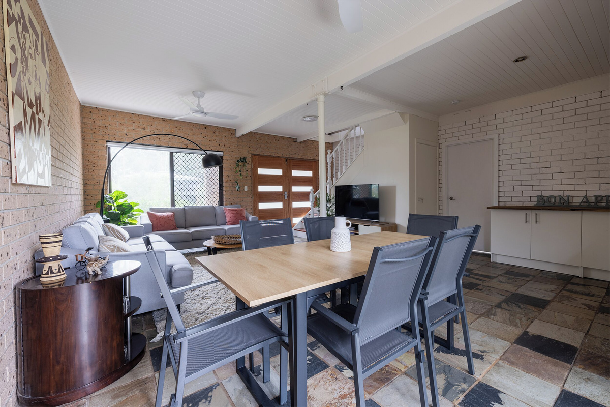 The downstairs space at Luna’s Sanctuary features dining, lounge seating, TV, kitchenette-style bench and direct connection to the entry and stairs.