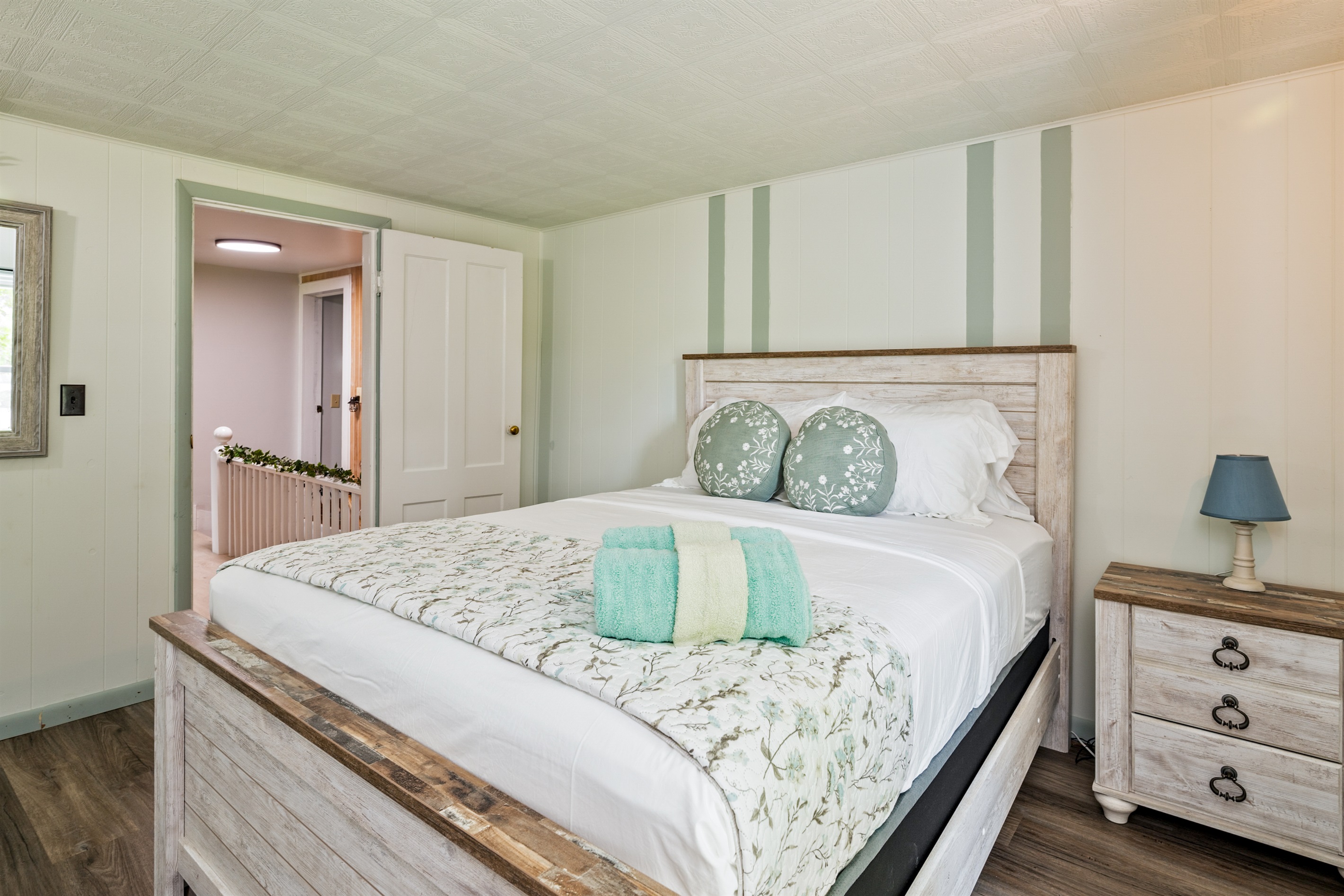 Relax in this serene bedroom featuring cozy floral accents, soft lighting, and peaceful views—perfect for a restful night's sleep.