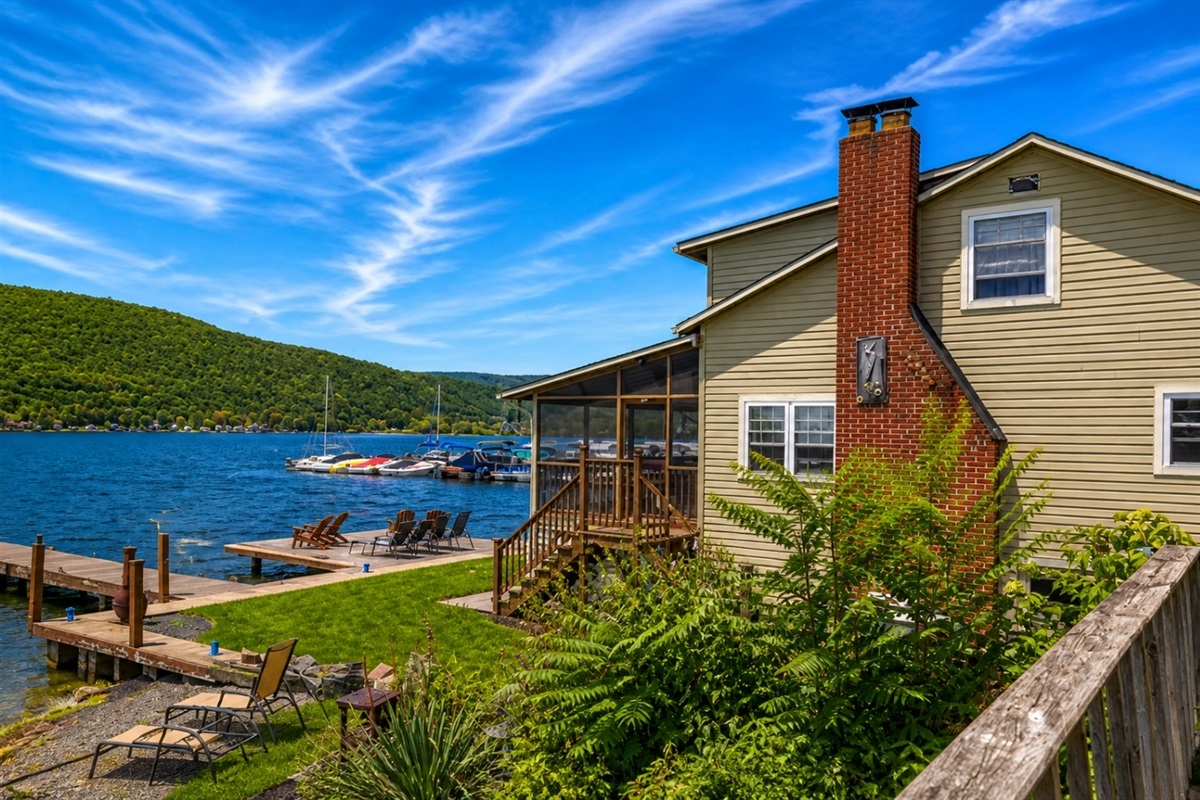 Discover the charm of this remarkable home with a captivating side view that reveals a private dock extending gracefully into the water. From this perspective, the house beautifully blends with its serene lakeside surroundings, offering the perfect s