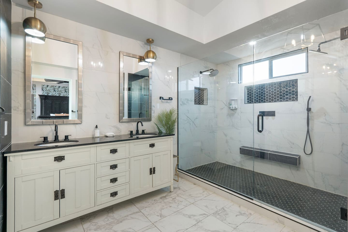 Spa-inspired primary bath with marble accents, frameless glass shower, and elegant finishes.