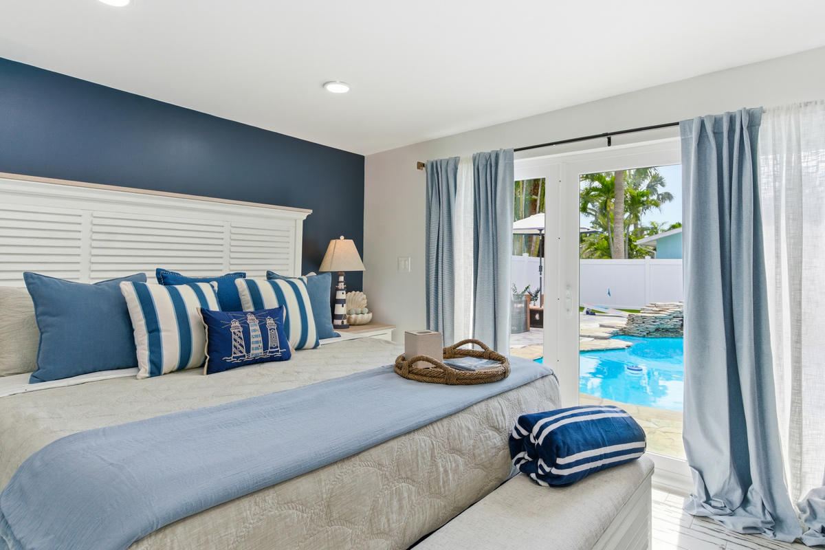 Welcome to the Sailhouse primary bedroom that looks out onto the pool area.