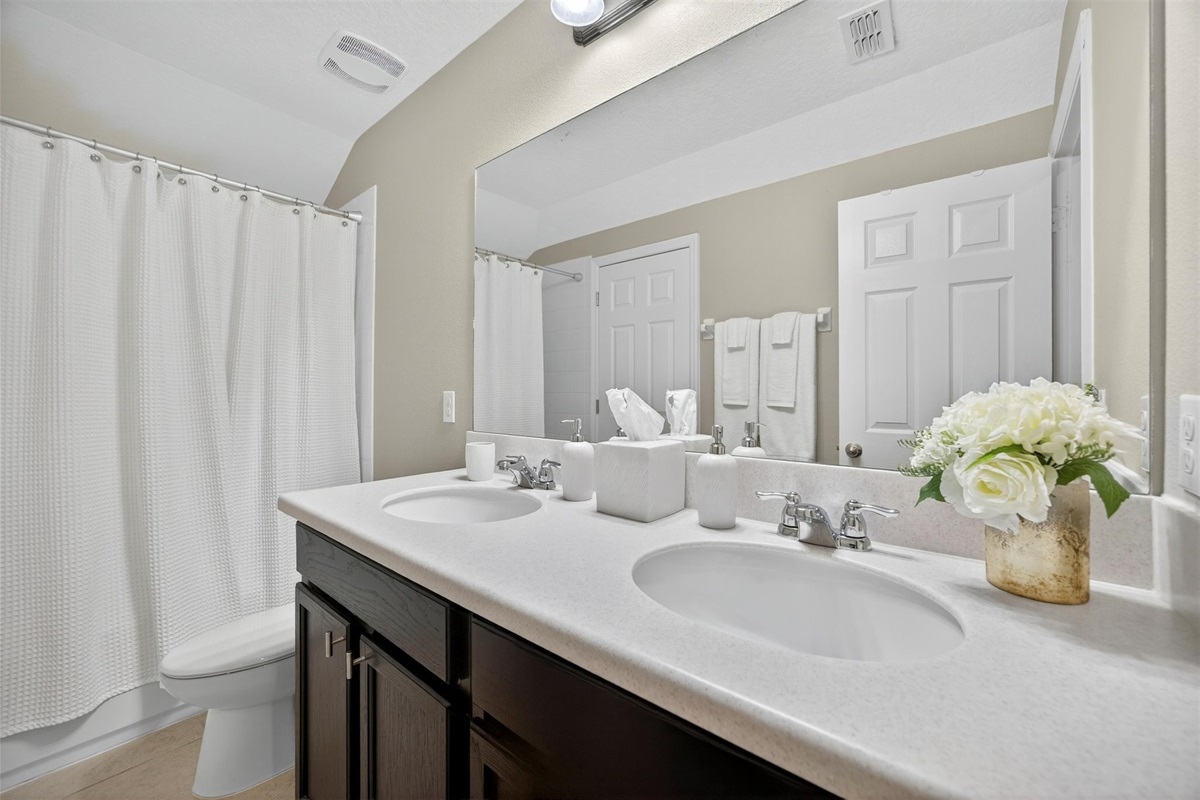 Bright guest bathroom with fresh linens and full amenities.