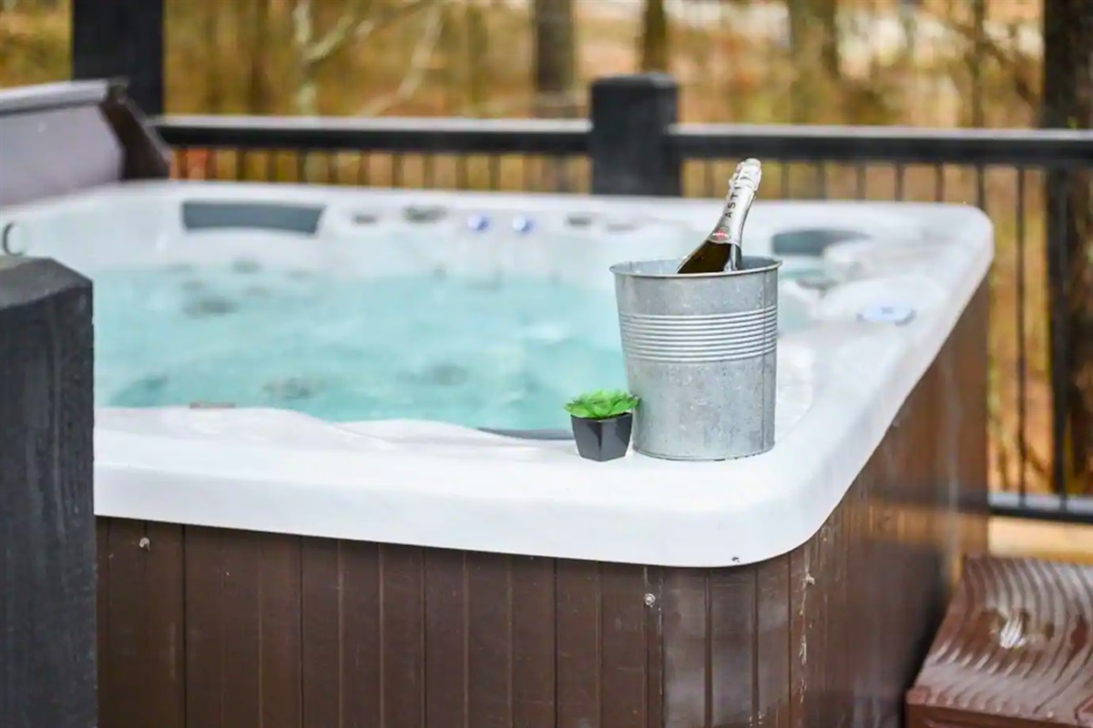 Unwind in luxury with a bottle of champagne in an ice bucket next to a bubbling hot tub