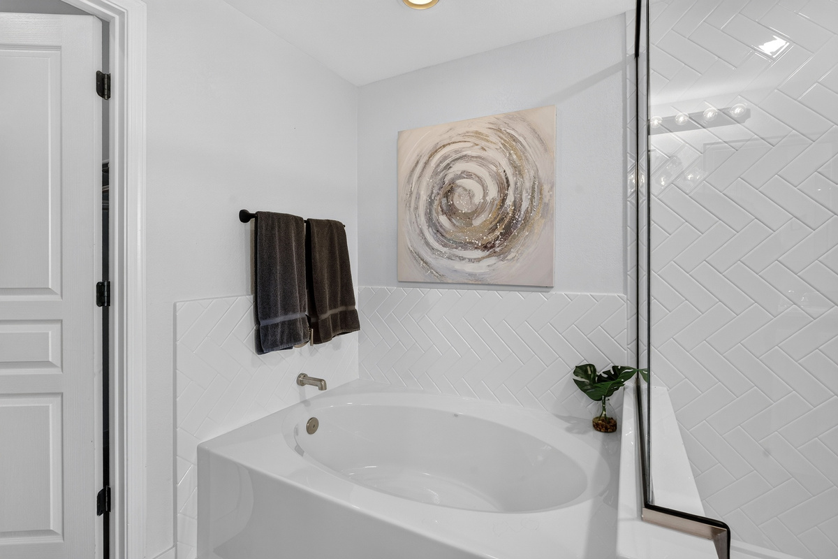 Bathroom with vanity storage, walk-in shower, soaking tub, and clean updated finishes for daily routines.