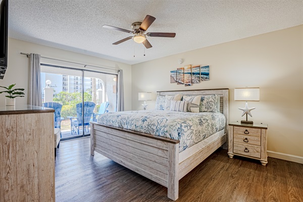 Master bedroom with patio access, ceiling fan and smart TV