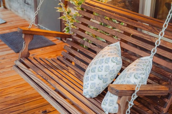 Swing into relaxation on the porch swing, surrounded by calm and nature.