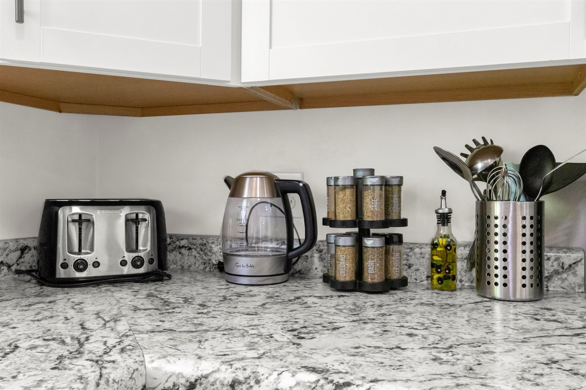Fully stocked kitchen with utensils, electric kettle, toaster, and an assortment of spices and olive oil provided.