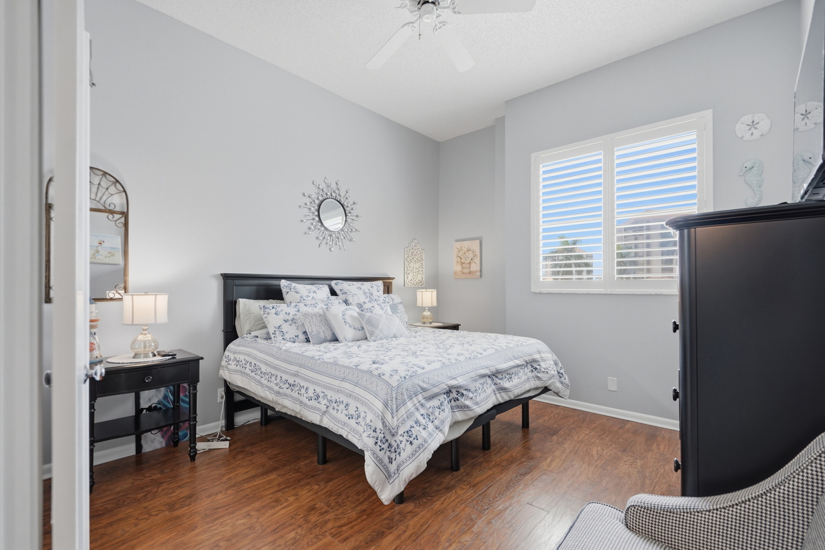 Unwind in the comfortable primary bedroom featuring a king-size bed, walk-in closet, ceiling fan, and easy access to the full bathroom. It's a peaceful retreat to relax and recharge after a day in the Florida sunshine.