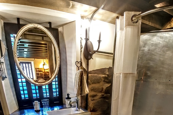 Lower Level Bedroom Suite: Vanity and Shower - the original historic window is covered by the bathroom mirror
