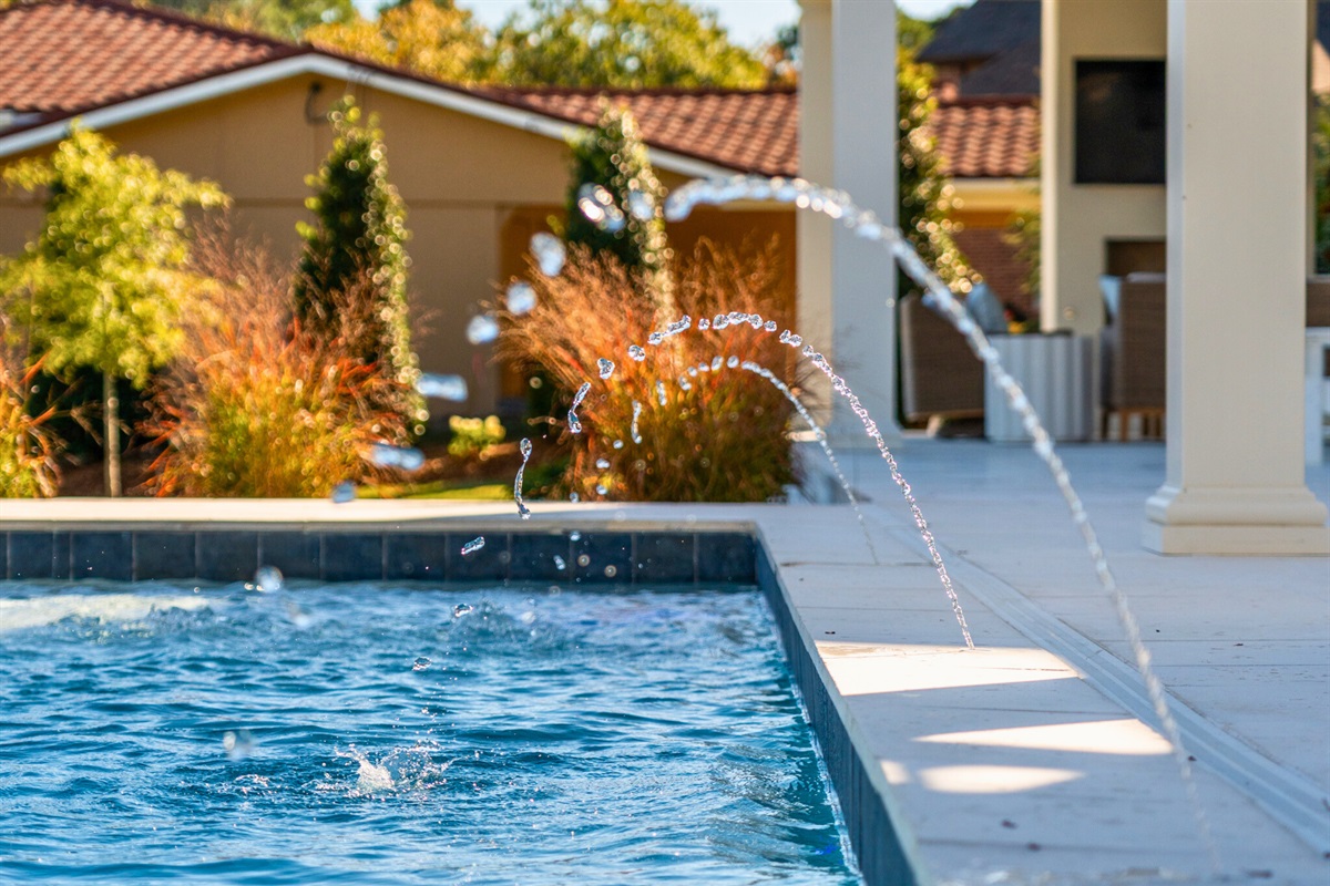 Pool illuminated at dusk with warm, inviting glow.