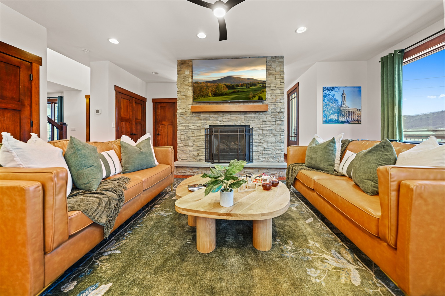 Bright, open living room with deep leather seating and fireplace — ideal for gathering, relaxing, and watching the big game together.
