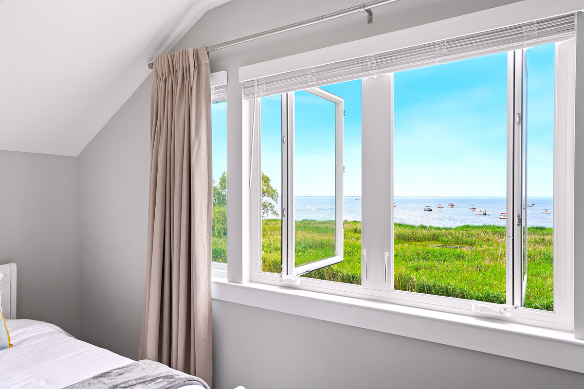 Natural light pours into the room while peaceful views of Lake St. Clair's sandy swimming area create the perfect backdrop for a relaxing waterfront getaway.