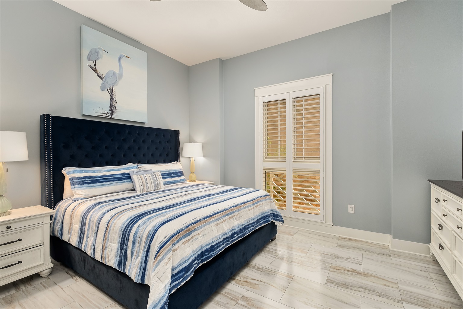 Relax in the spacious master bedroom, complete with a plush king bed and tranquil coastal decor. Perfect for unwinding after a day of adventure.