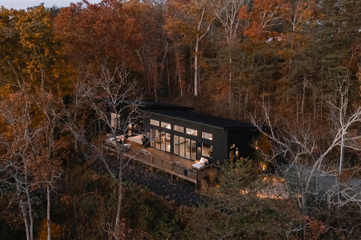 {Exterior Aerial- Glass House} Rising above the treetops on 3 secluded acres, this home offers serenity and sweeping views, all just a quick 12-minute drive from Asheville.