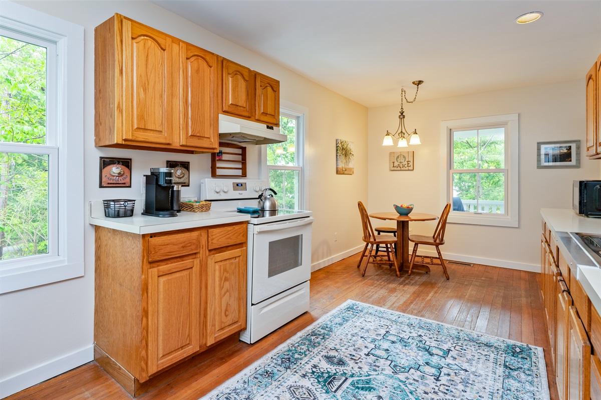 Bright and welcoming kitchen with warm wood cabinetry, modern appliances, and a cozy dining nook—perfect for morning coffee or casual meals.