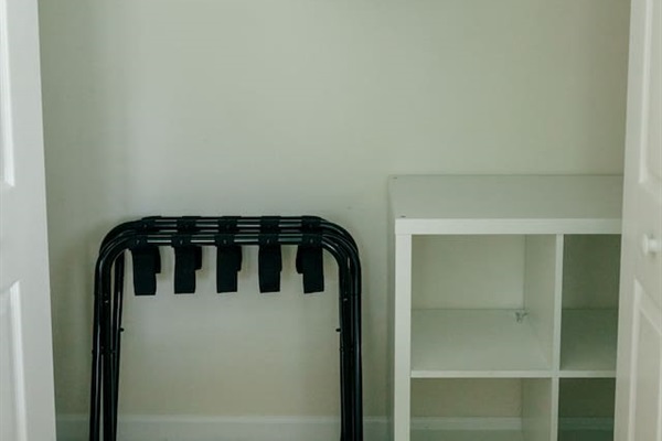 Ample closet space with 2 luggage racks, hangers, laundry basket, and extra pillows. 