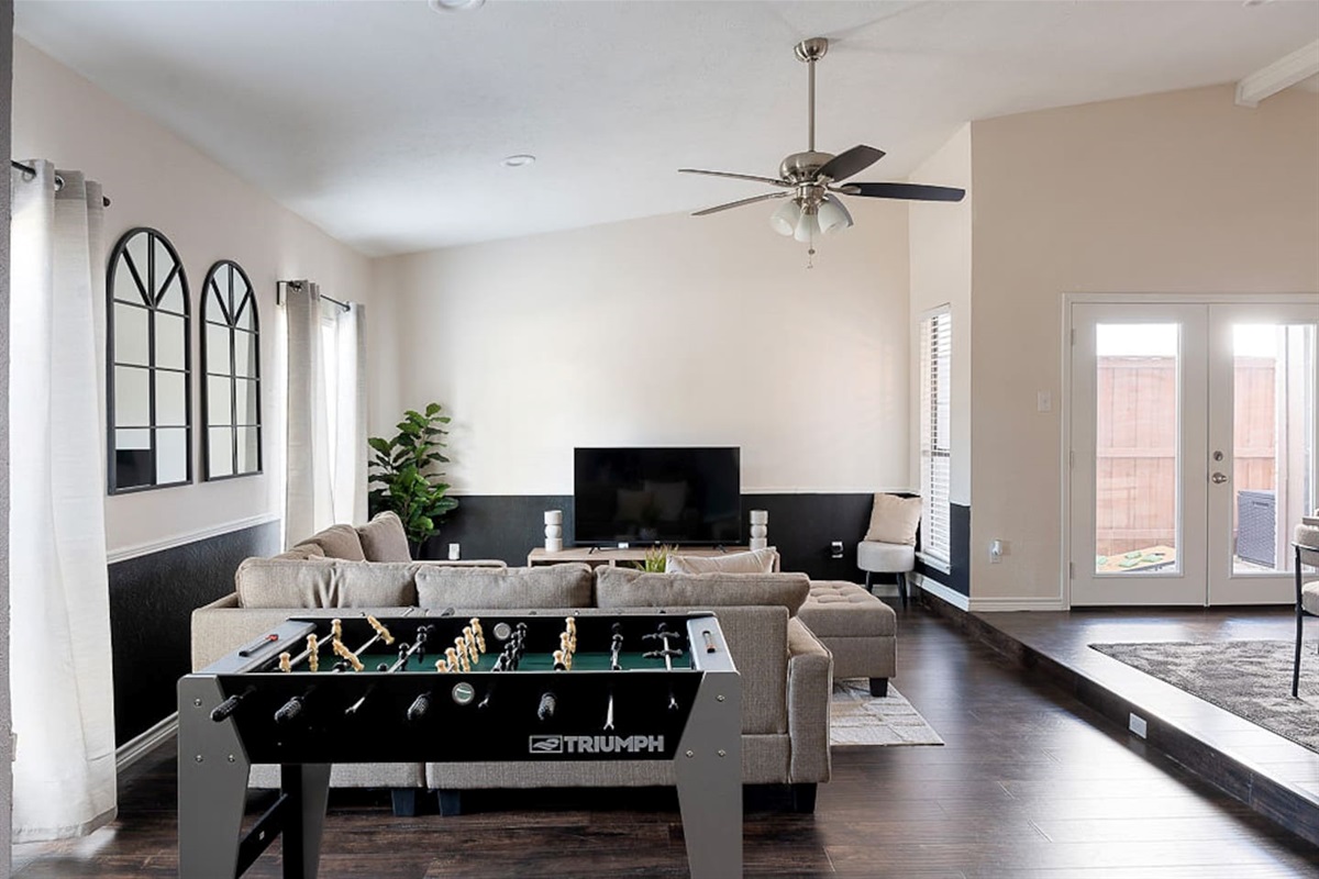 Relax on the comfortable couch next to the 65" HDTV or stand for a game of foosball