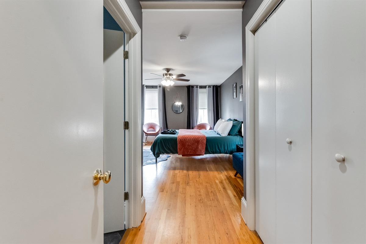 Queen Bedroom 3: Relax in a stylish retreat with vibrant decor and warm wood floors!