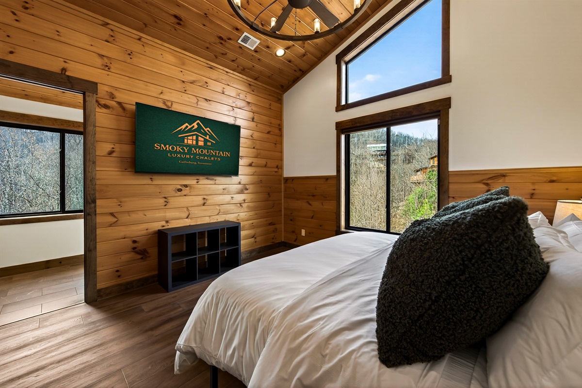 King Suite with vaulted ceilings an x-large TV. Unwind in the en-suite bathroom featuring a luxurious walk-in shower with a natural river rock floor, bringing  the Smoky Mountains indoors for a spa retreat.