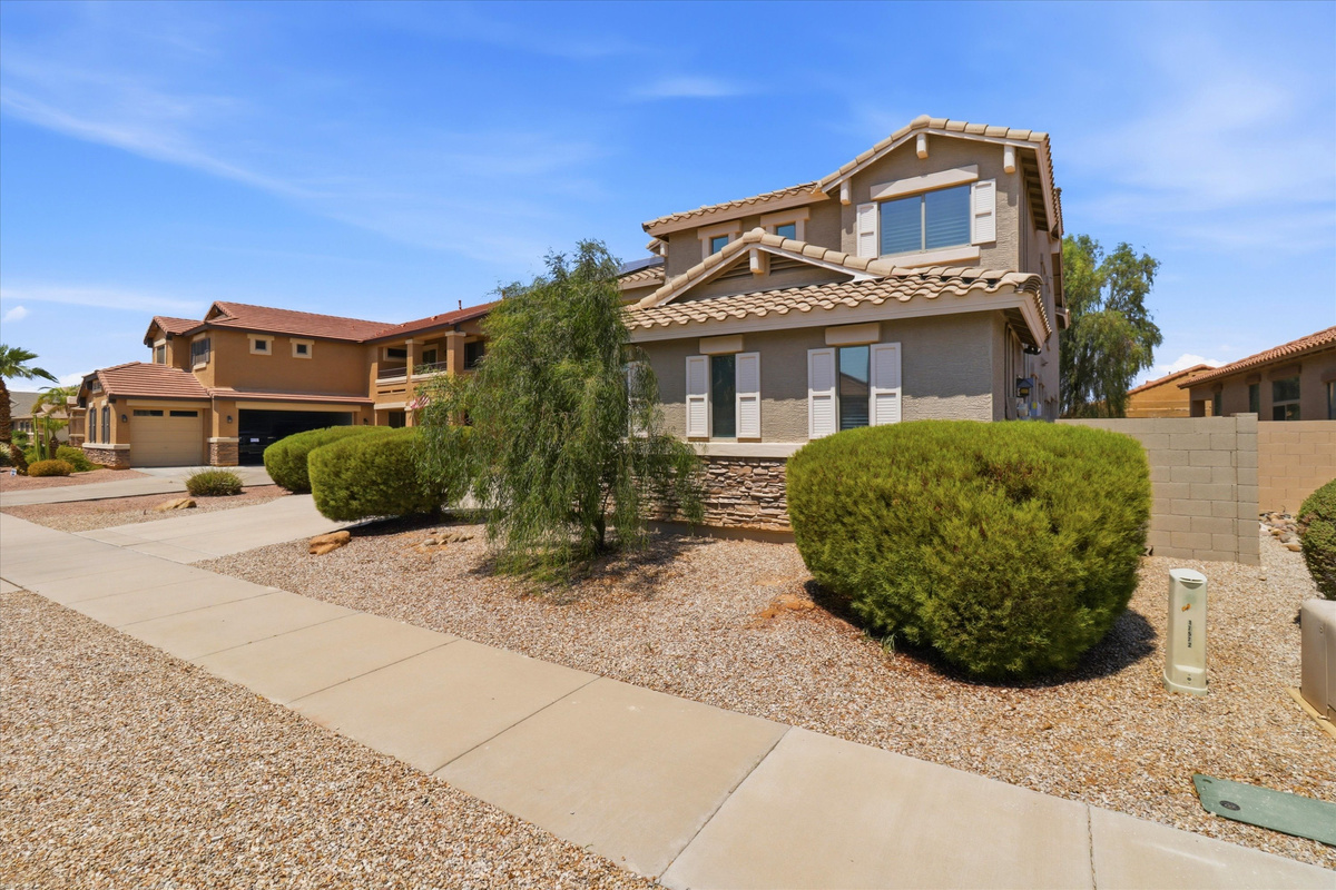 Front exterior with desert landscaping, sidewalk access, and a clean view of the home from the street.

