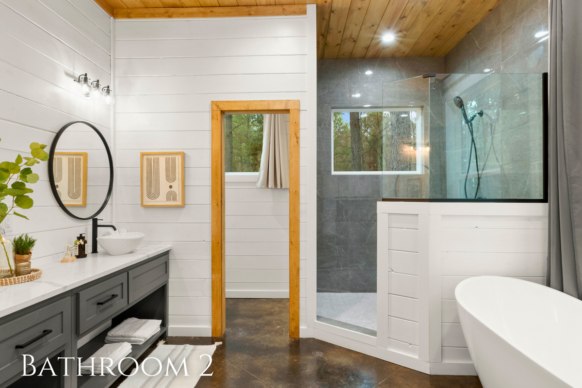 The round mirrors add a contemporary flair, complemented by warm wood tones and greenery that bring a natural, calming vibe to the room.