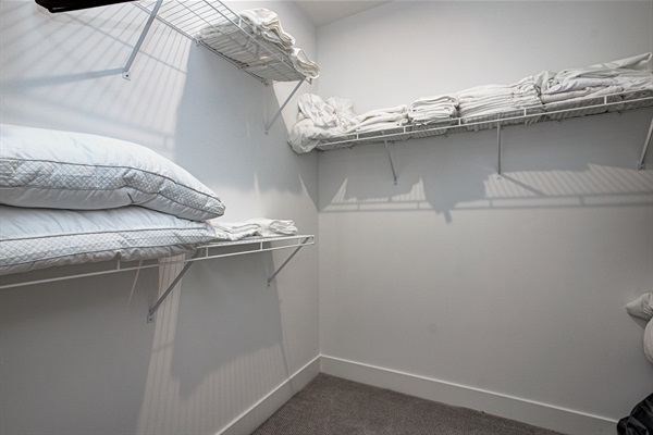 Relax in the serene master bedroom featuring a comfortable king-size bed, soft linens, and cozy pillows. Includes nightstands, lamps, walk-in closet, and full-length mirror for added comfort. 