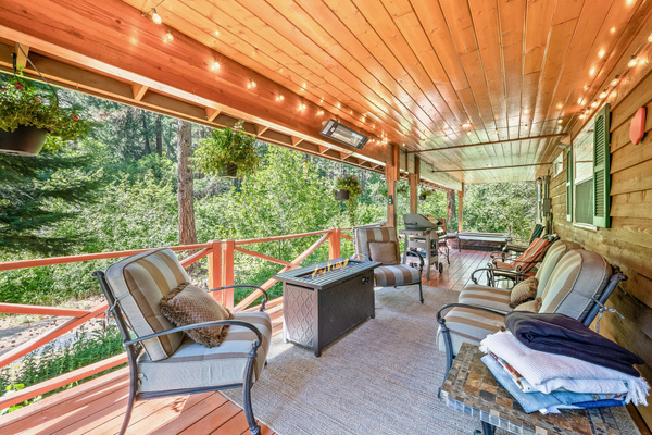 Large covered back porch includes seating, fire table, outdoor heater, BBQ and hot tub