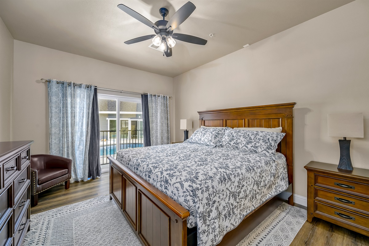 Main level king suite #2 with slider out to pool area and ensuite bathroom. There are a total of 4 stairs to navigate down to reach this bedroom.