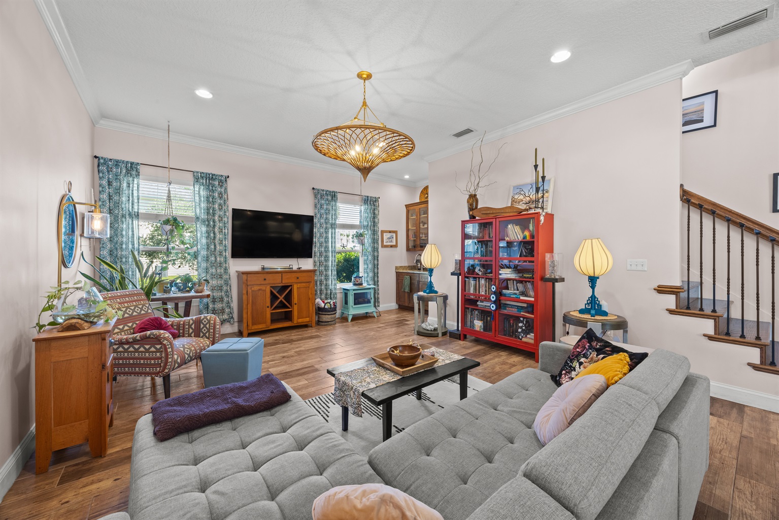 Stylish living room with sectional sofa, eclectic décor, and plenty of natural light.