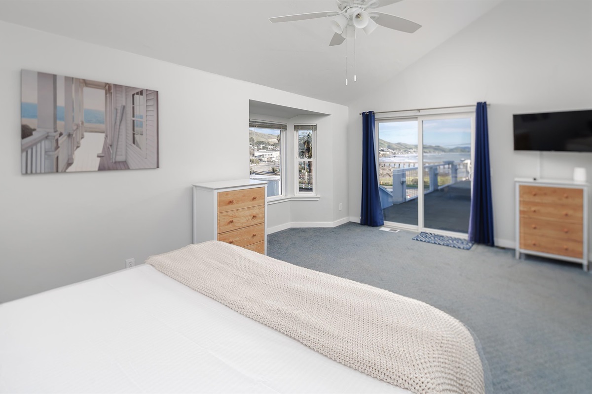 A spacious, bright bedroom designed to make everyone smile — with a big glass slider overlooking the ocean.