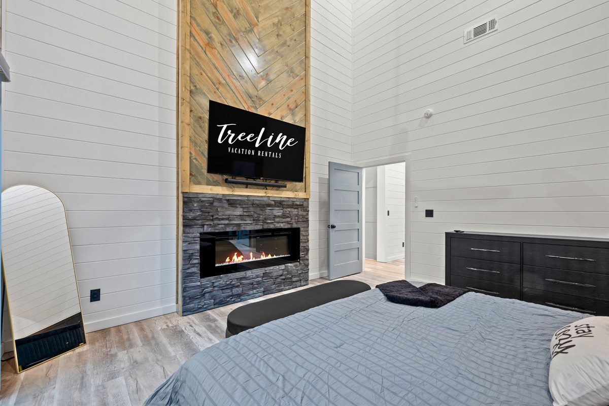 The addition of a fireplace adds an extra layer of comfort to this bedroom, creating a cozy spot to relax on cooler evenings.
