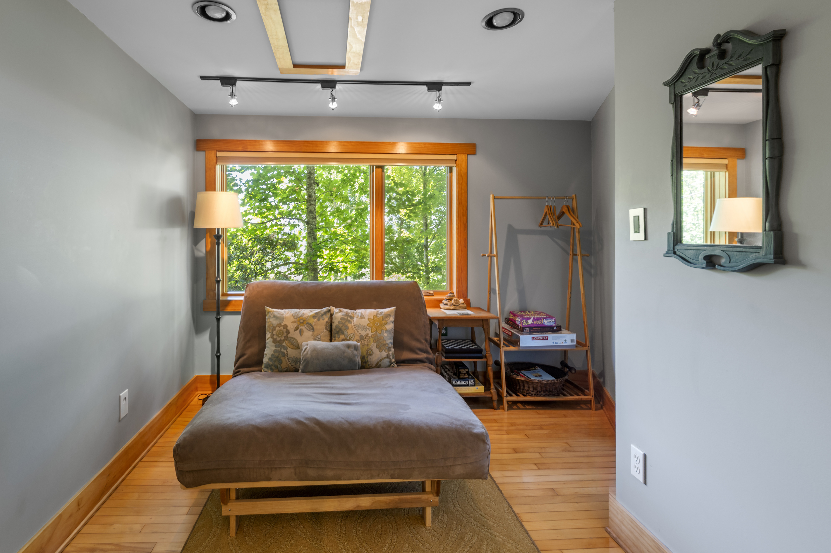 Lounging futon converts to a full-size bed and faces another window behind desk
