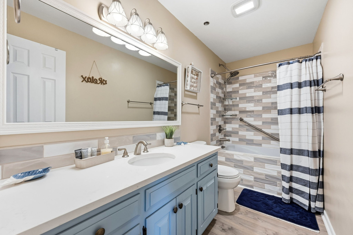 A private ensuite bathroom with an abundance of cabinet space and tub/shower combo