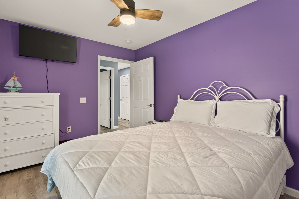 Bedroom with dresser and wall-mounted television