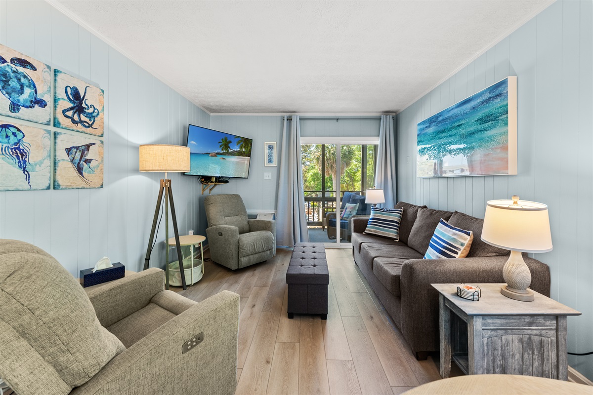 Spacious Living Room area with large TV, sleeper sofa and access to patio.