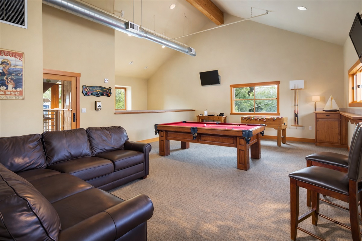 Communal / shared game room with pool table, foosball, darts, card table, plus DVD and board games rentals